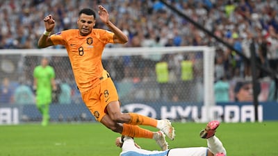 Cody Gakpo falls over Argentina midfielder Leandro Paredes. AFP