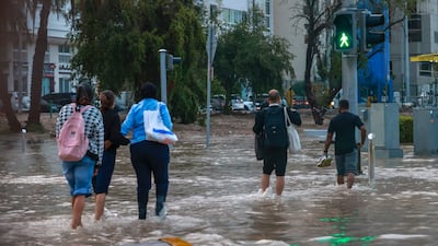 Residents walk through the water in care feet in Abu Dhabi. Victor Besa / The National
