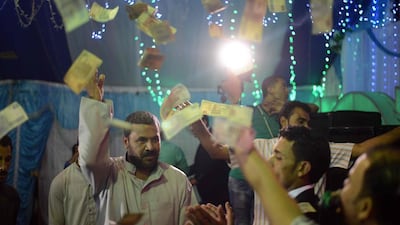 Egyptian men dance at a wedding party in the Egyptian Nile Delta province of Al Minufiyah on May 24, 2016. Such parties - which gather participants for the cooperative savings system - have become more common in Egypt in the past few years as economic conditions deteriorate. Mohamed El Shahed/AFP