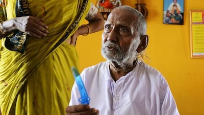 Indian monk Swami Sivananda reacts after his followers presented him with a birthday cake in Kolkata.
