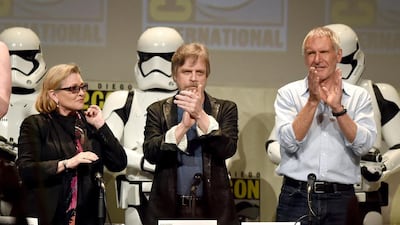 Actors Carrie Fisher, Mark Hamill and Harrison Ford applaud onstage at the Lucasfilm panel during Comic-Con International 2015 at the San Diego Convention Center on July 10, 2015 in San Diego, California. Kevin Winter / Getty Images / AFP