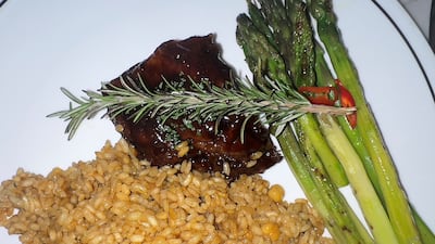 The glazed slow-cooked beef short ribs, which take 18 hours in the oven, are served with rice. Phil Johnson / The National