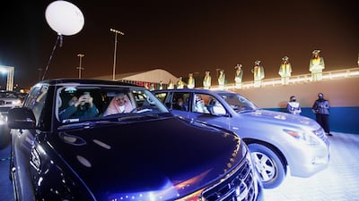 A family member takes a photo from a car during the drive-through Visual Graduation Ceremony 2021 for pupils at Bahrain Bayan School. Reuters