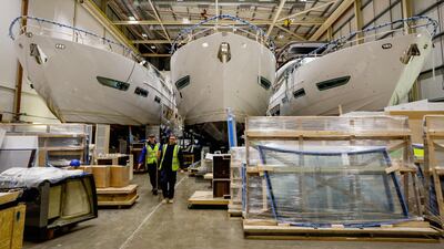 Employees pass by three under-construction Princess Y85 motor yachts in the boat shed at the Princess Yachts Newport Street site in Plymouth, U.K., on Tuesday, March 12, 2019. The current economic climate, with a growing class of super-rich, has been good for the yacht trade, and Princess, which earned almost £30 million ($36 million) on revenue of some £340 million in 2018, has been among the lucky beneficiaries. Photographer: Luke MacGregor/Bloomberg