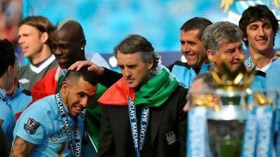 Although he played a vital part in rejuvenating Manchester City's strong finish to the season, Carlos Tevez, left, is likely to be moved on by Roberto Mancini, right, if the club's valuation is met. Paul Ellis / AFP