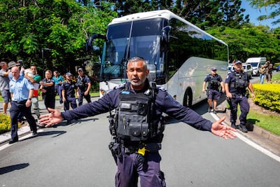 Police officers clear the road for a departing bus transporting members of the Iranian women’s football team, outside the Royal Pines Resort on the Gold Coast on March 10, 2026. AFP
