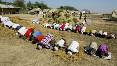 SITTWE, MYANMAR - NOVEMBER 23: Rohingya boys pray during Friday prayer next to hay at a tented IDP camp November 23, 2012 on the outskirts of Sittwe, Myanmar. An estimated 111,000 people were displaced by sectarian violence in June and October effecting mostly the ethnic Rohingya people who are now living in crowded IDP camps racially segregated from the Rakhine Buddhists in order to maintain stability. Around 89 lives were lost during a week of violence in October, the worst in decades. As of 2012, 800,000 Rohingya live in Myanmar. According to the UN, they are one of the most persecuted minorities in the world. (Photo by Paula Bronstein/Getty Images)