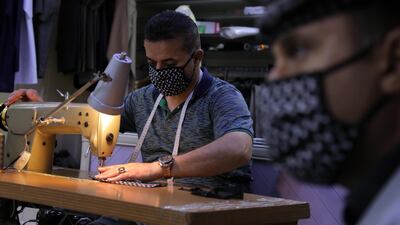 A Kurdish tailor makes face masks out of keffiyeh fabric in Erbil, northern Iraq. AFP