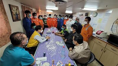 A South Korean official (centre L - yellow vest) meets the crew of the Hankuk Chemi, a tanker seized by Iran, on the ship in Iran on February 3. AFP / South Korean Foreign Ministry