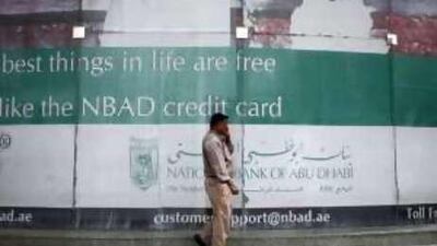 A credit card ad in the window of National Bank of Abu Dhabi.