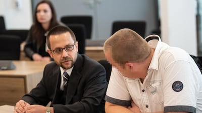 One of the defendants (right) with his lawyer. The accused's face has been hidden because of a German legal order. EPA
