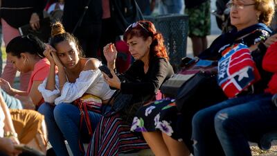 People wait in a park to be called on by the nearby US embassy. AP