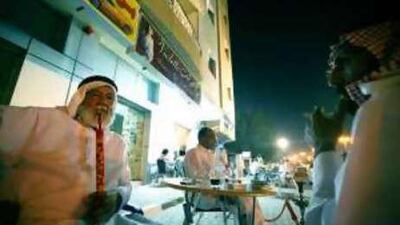 Patrons relax at Al Forat coffee shop in Ajman. The cafe's generator cannot power the air conditioner, forcing them to bear the heat.