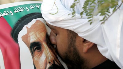 An Emirati man kisses a picture of Sheikh Zayed during his funeral. Rabih Moghrabi / AFP