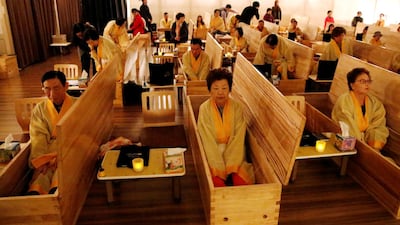 Participants sit inside coffins during a "living funeral" event as part of a "dying well" programme, in Seoul, South Korea. Reuters