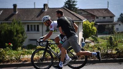 Solvakian rider Peter Sagan is pushed by a member of Team Bora after a technical problem. AFP