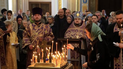 A woman places a lit candle as people attend a memorial service at the Alexander Nevsky Cathedral in Simferopol, Crimea. AFP