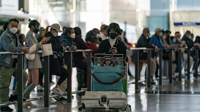 Travellers walk with their luggage at the arrivals hall of Hong Kong International Airport. Getty