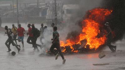 People run at a protest as barricades burn during rainfall in Harare, Zimbabwe January 14, 2019. REUTERS/Philimon Bulawayo TPX IMAGES OF THE DAY