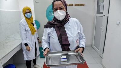 A medical worker walks with a pack of Russia's Sputnik V vaccine for Covid-19 at a clinic in the city of Blida. AFP