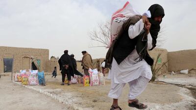 People receive food distributed by the Afghan Charity Foundation in Kandahar, Afghanistan. EPA