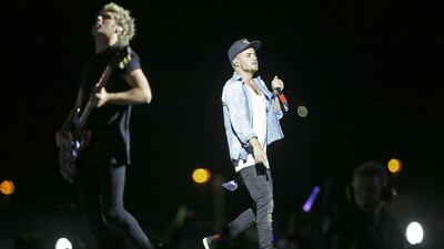 Youthful Niall Horan, in a plain black tee is happiest on the many songs he has a guitar round his neck. Liam is the mouthy, cheeky one, decked in a baggy open blue shirt, white vest and Adidas cap. Sarah Dea / The National