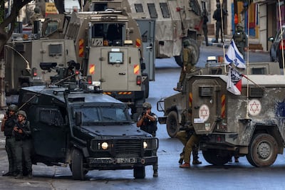 Israeli army vehicles block a road during a raid in Nablus, in the occupied West Bank, on Sunday. AFP
