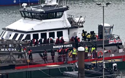 Migrants are escorted ashore from a UK Border Force vessel in Dover earlier this month. AFP