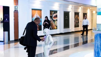 A man shakes hands with Pepper the robot in Emirates Towers. All photos by Reem Mohammed / The National