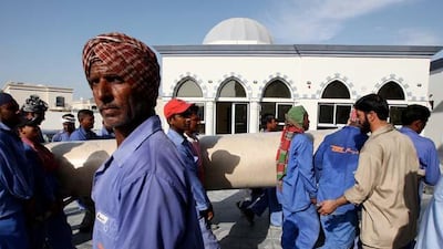 Workers carry the carpet roll at the Al Farooq mosque in Al Safa area in Dubai.