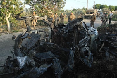 Members of the Lebanese army stand in front of a car targeted by an Israeli air strike on the road of the southern town of Jouaiya on January 7, 2026. AFP