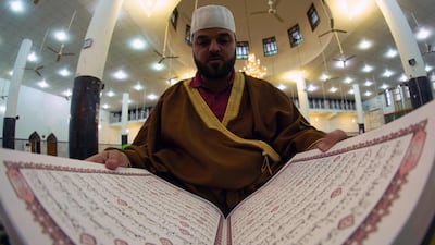The muezzin of the grand mosque of Basra, closed down due to the coronavirus pandemic, reads the Quran. AFP