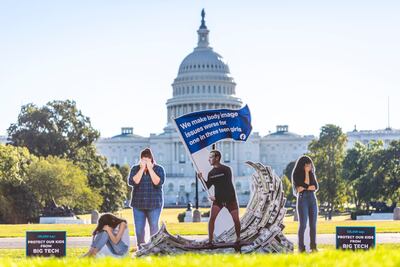 A visual protest depicting Facebook chief executive Mark Zuckerberg surfing on a wave of cash and flanked by women in distress, outside the US Capitol in Washington. AP