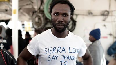 A migrant shows a thank you note to Spain written on his t-shirt as he waits to disembark from the Aquarius rescue ship in the port of Valencia. Handout via Reuters