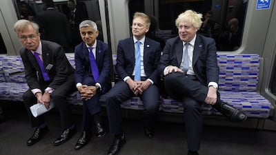 British Prime Minister Boris Johnson with Transport Secretary Grant Shapps, centre right, and Mayor of London Sadiq Khan, centre left, on an Elizabeth Line train at Paddington station. PA