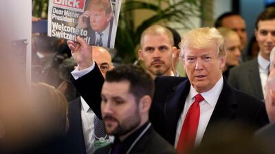 epaselect epa06475273 US President Donald J. Trump holds up Swiss newspaper Blick as he arrives at the Congress Centre on the last day of the 48th annual meeting of the World Economic Forum (WEF) in Davos, Switzerland, 26 January 2018. The meeting brings together entrepreneurs, scientists, chief executive and political leaders in Davos from 23 to 26 January. EPA/LAURENT GILLIERON