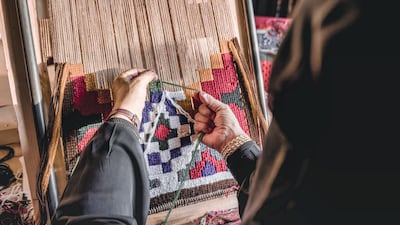 Khalid Harthi, Saudi Arabia: A woman is shown practicing the traditional art of embroidery as she knits and weaves her art into a frame to be displayed in the Okaz Souq near Ta’if.