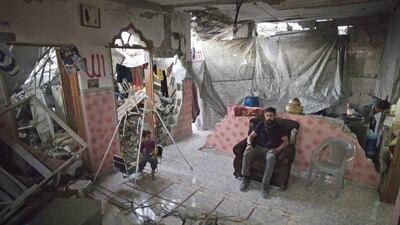 Madi Hasanein sits in the living room while his son swings in what is left of his home in the Tofah neighbourhood of Gaza City. The UN says that at this rate, it will take decades to rebuild Gaza from the damage sustained in last summer’s 50-day war. Khalil Hamra, AP Photo