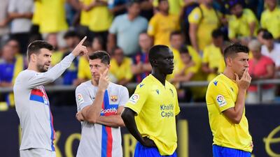 Barcelona players Gerard Pique and Robert Lewandowski, Cadiz players Awer Mabil and Ruben Alcaraz wait during the interruption. AFP