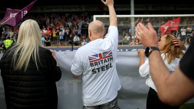 Steelworkers, members of the Unite union and their supporters hold banners and flags at a rally at Scunthorpe United Football club's ground. Getty Images