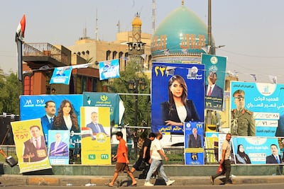Iraqis walk past election posters in Baghdad on November 7, 2025. The country now faces a crisis with a caretaker government operating under restricted executive authority. EPA