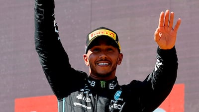 Mercedes' Lewis Hamilton celebrates with a trophy on the podium after finishing second. Reuters