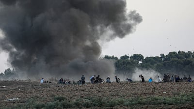 Protesters take cover after Israeli strikes on Friday. Israel says three Hamas sites in Gaza were targeted in response to border riots. EPA