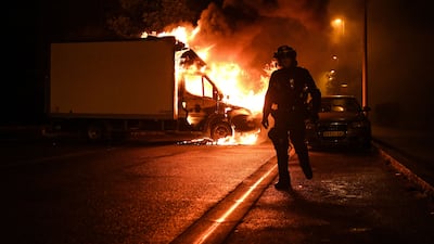 A policemen walks past a burning lorry in Nantes, western France, amid protests. AFP