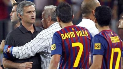 Jose Mourinho, left, gets involved in the fracas between Barcelona and Real Madrid players and staff last night.