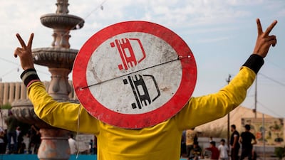 An Iraqi protester wearing a road sign on his head as a means of protection, flashes the victory gesture with his fingers as he takes part in an anti-goverment demonstration in the southern city of Basra. AFP