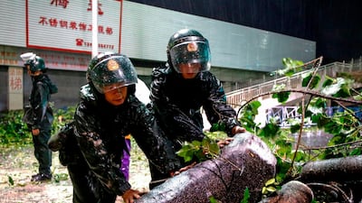 Paramilitary Police officers clean up damaged trees and branches on road after super Typhoon Mangkhut in Zhongshan, south China's Guangdong province. AFP