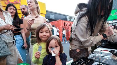 Young visitors admire the silver necklaces and rings at the Coral Beach stall owned by Ibrahim Bader. Thirty per cent of all profits will be donated to Palestine