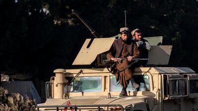 Taliban fighters on guard at the site of an explosion near a military airfield in Kabul. AP