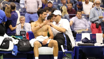 Novak Djokovic of Serbia is looked over by a trainer during a break in play. AFP